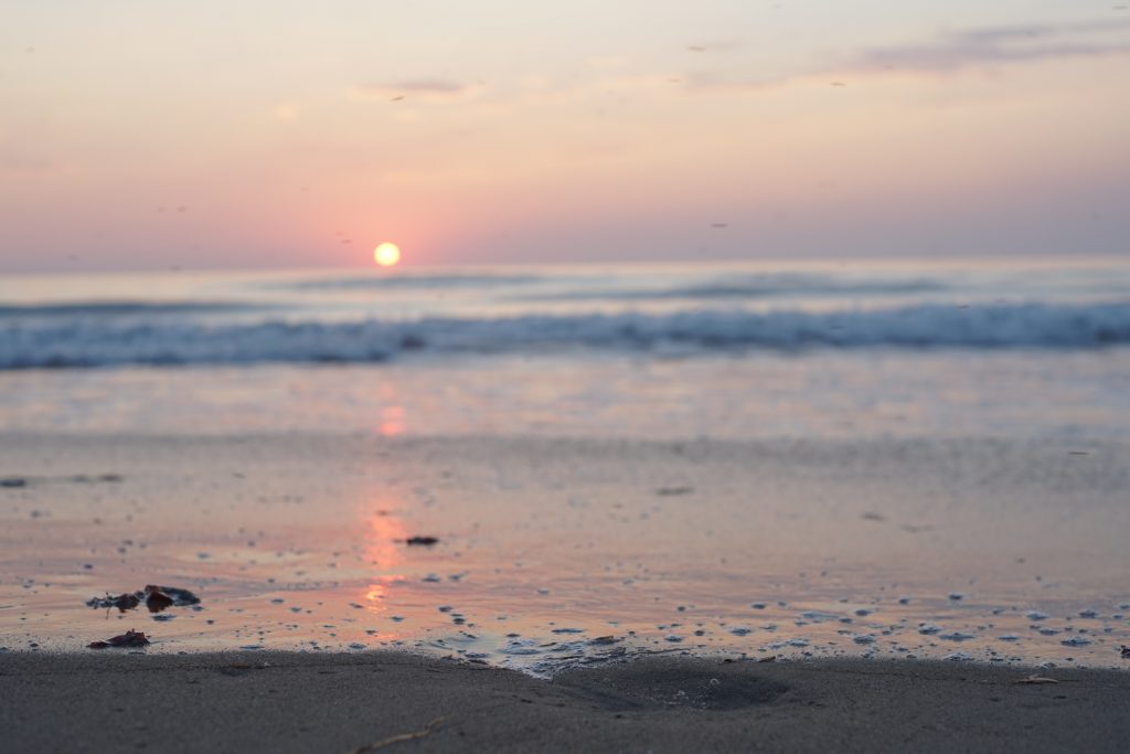 setting sun over a reddened beach